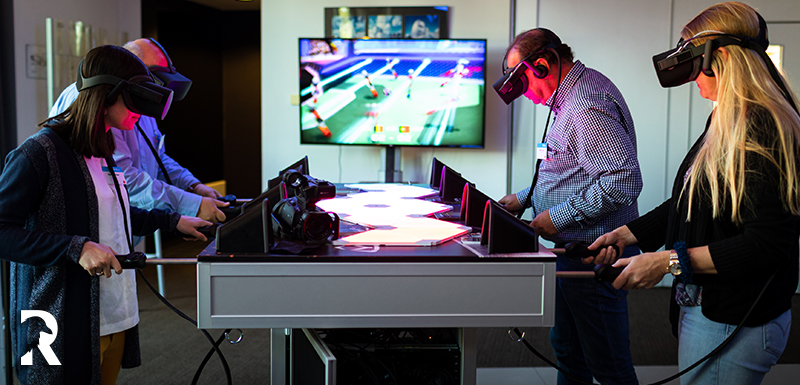 4 persons playing VR table soccer